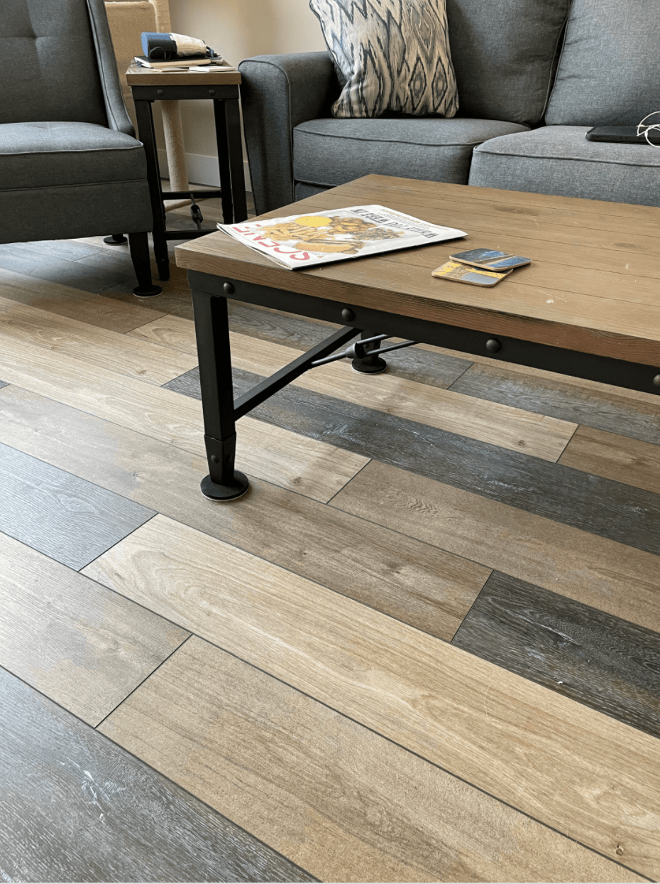 Luxury vinyl plank installation in a living room with a coffee table. Furniture is in the background.